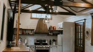 Une cuisine rustique avec des poutres en bois, un coin bar et un tapis en peau de vache.