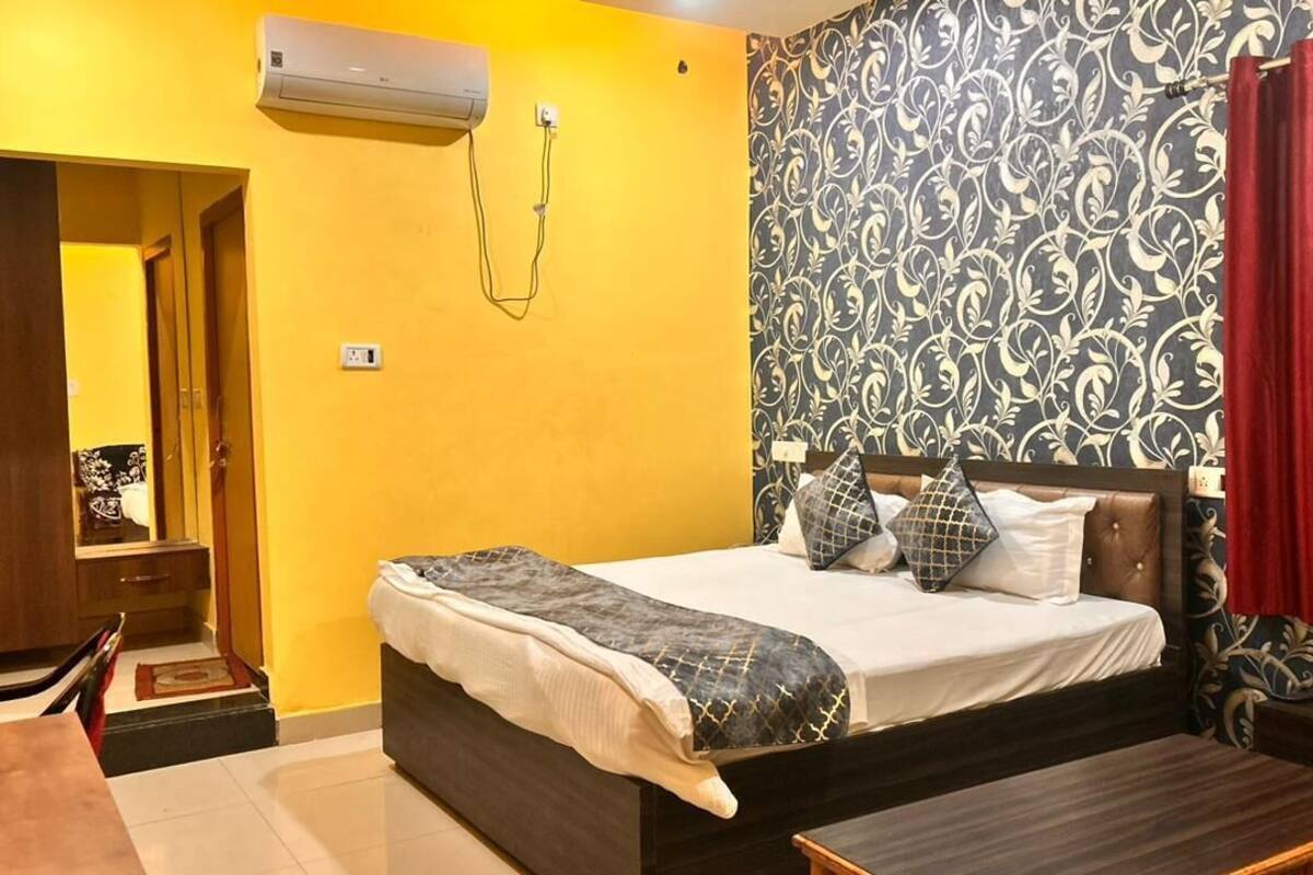 Une chambre à coucher comprenant un lit, une table de chevet, une armoire et un appareil de climatisation.