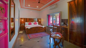 A bedroom with a large bed, a desk, and a chair. - Aaj Haveli by Levelup (Udaipur)