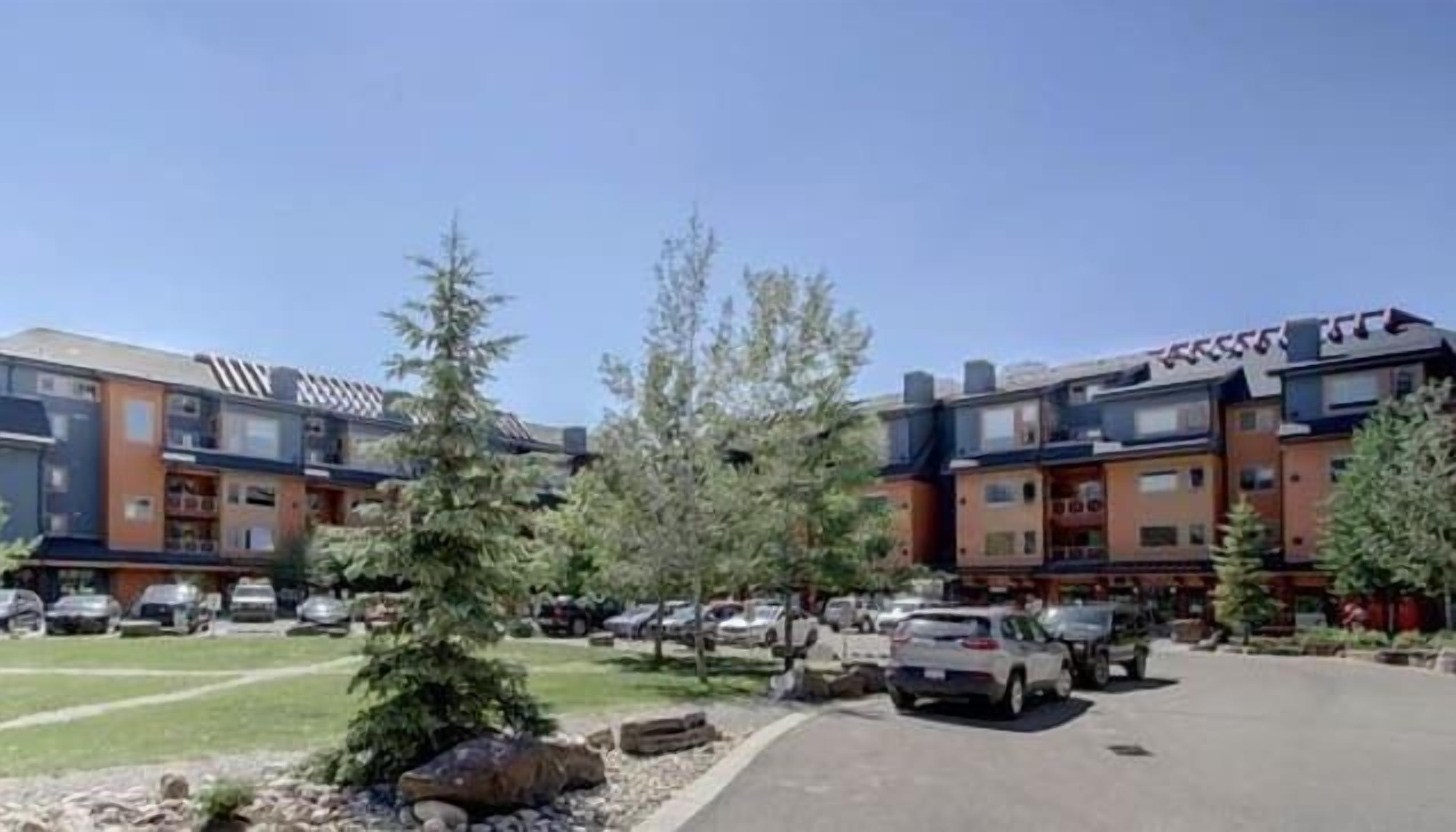 A multi-story building with a parking lot in front.