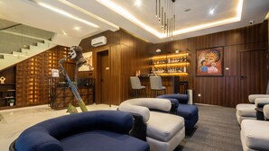 A modern living room with a staircase, seating area, and a bar. - George Residence Parkview (Lagos)