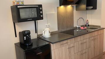 Een koelkast, een oven, een kookplaat, een koffiezetapparaat/waterkoker