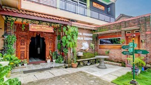 A traditional building with a wooden entrance, potted plants, and a signboard. - Hotel O Homestay Joglo Dephis Syariah (Borobudur)
