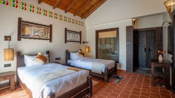 A room with two wooden beds, a large mirror, and a wooden ceiling.