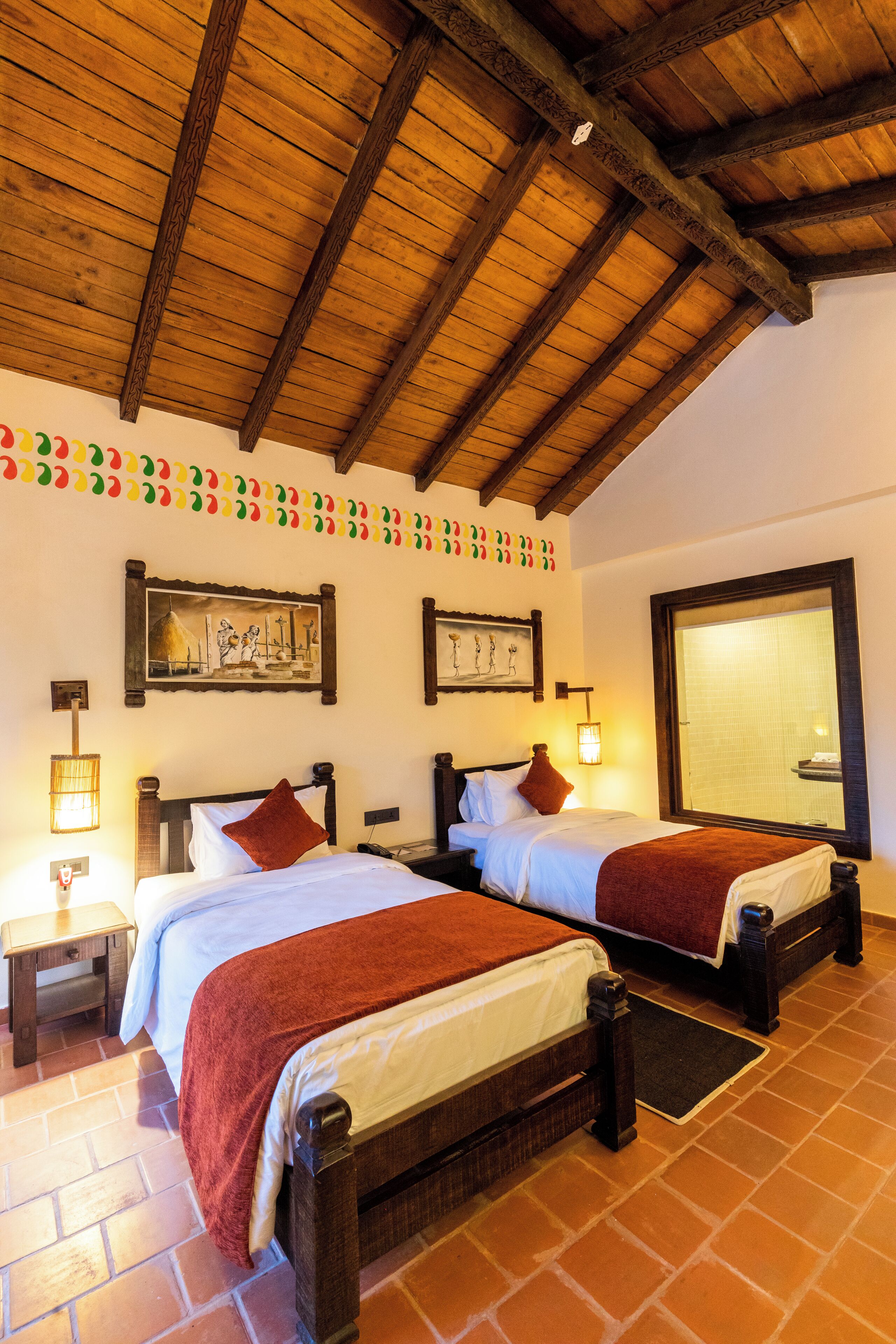 A hotel room with two wooden beds, a tiled floor, and a wooden ceiling.