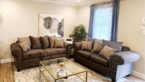 A living room with two sofas, a coffee table, and a ceiling fan.