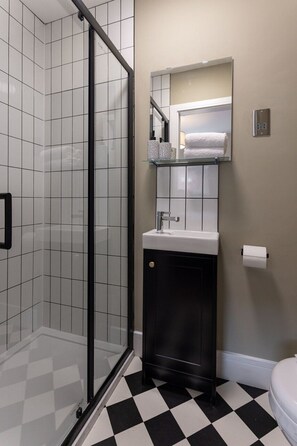 A bathroom with a glass shower enclosure, a white sink, a mirror above the sink, and a toilet. - Broughton Place 3: 3BR Modern Flat in Liverpool (Liverpool)