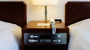 A hotel room with a wooden nightstand, a lamp, a telephone, and a control panel with various buttons and a digital display. - Tabist Hotel Nemuro Kaiyoutei (Nemuro)