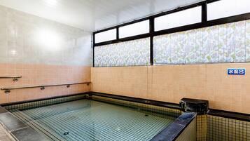 A tiled swimming pool with a tiled wall and a window with a colorful pattern.