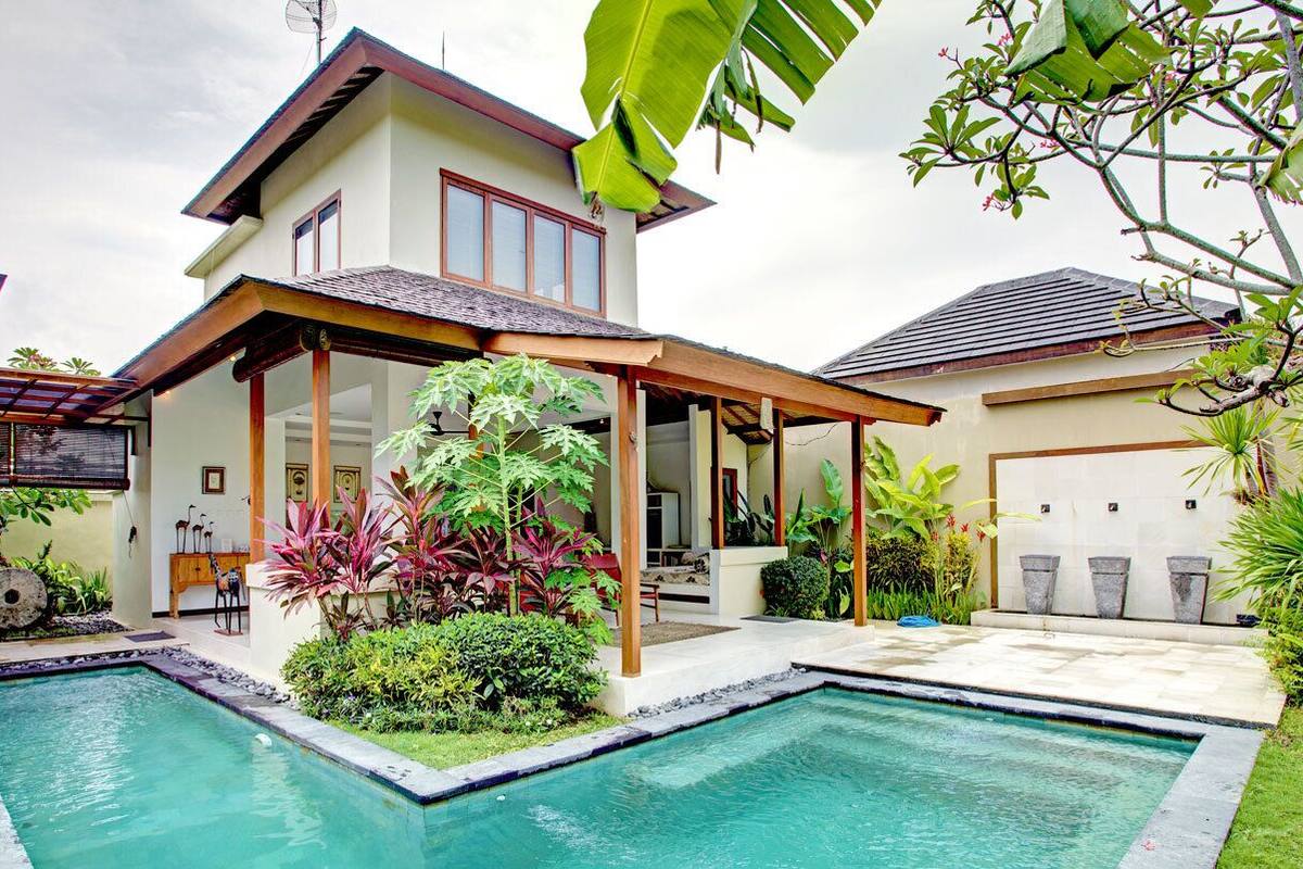 A two-story house with a swimming pool, a covered patio, and a garage.