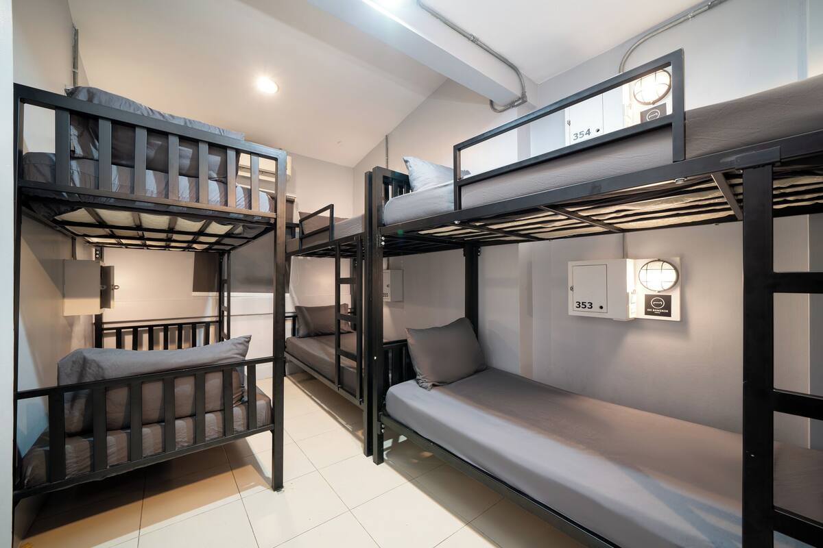 A bunk bed room with a desk and a lamp.