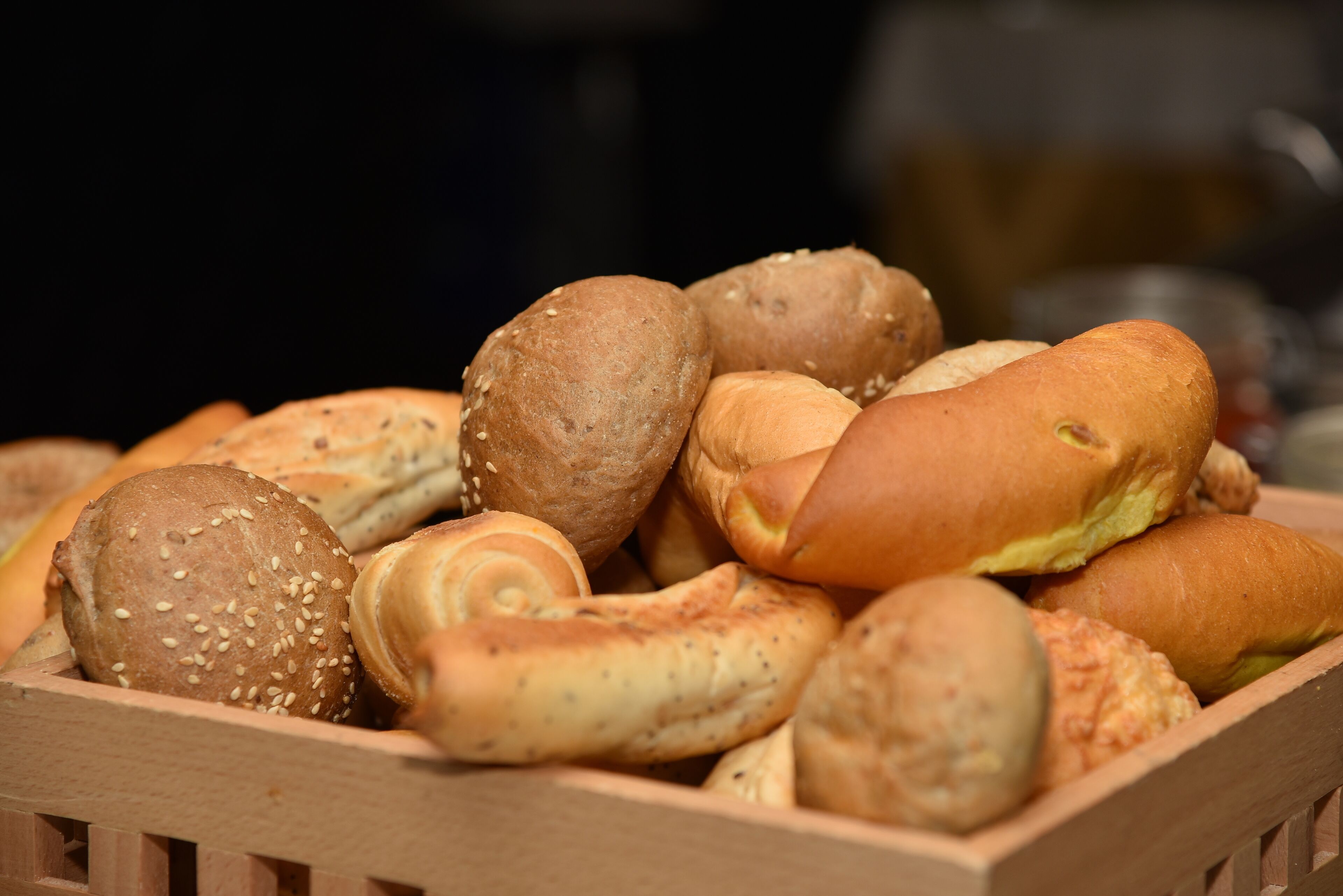 Een houten mand vol diverse soorten brood.