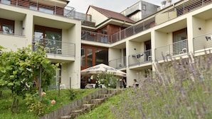 Ein mehrstöckiges Hotel mit Balkonen, Außenbereich und einem Garten mit Stufen und Blumen.