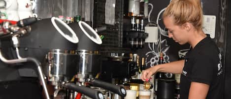 A barista preparing a drink at an espresso machine.