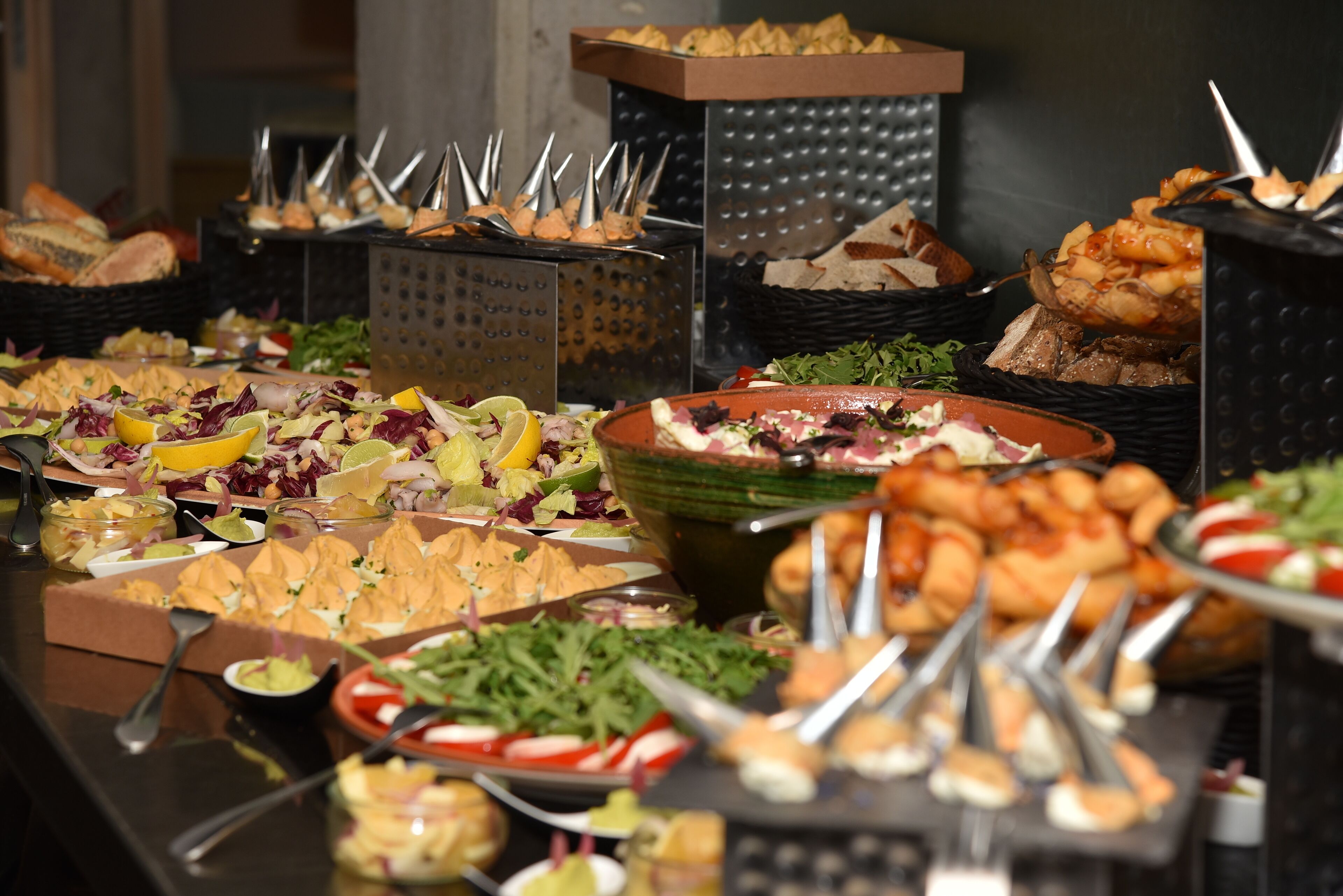 A buffet with various food items and utensils.