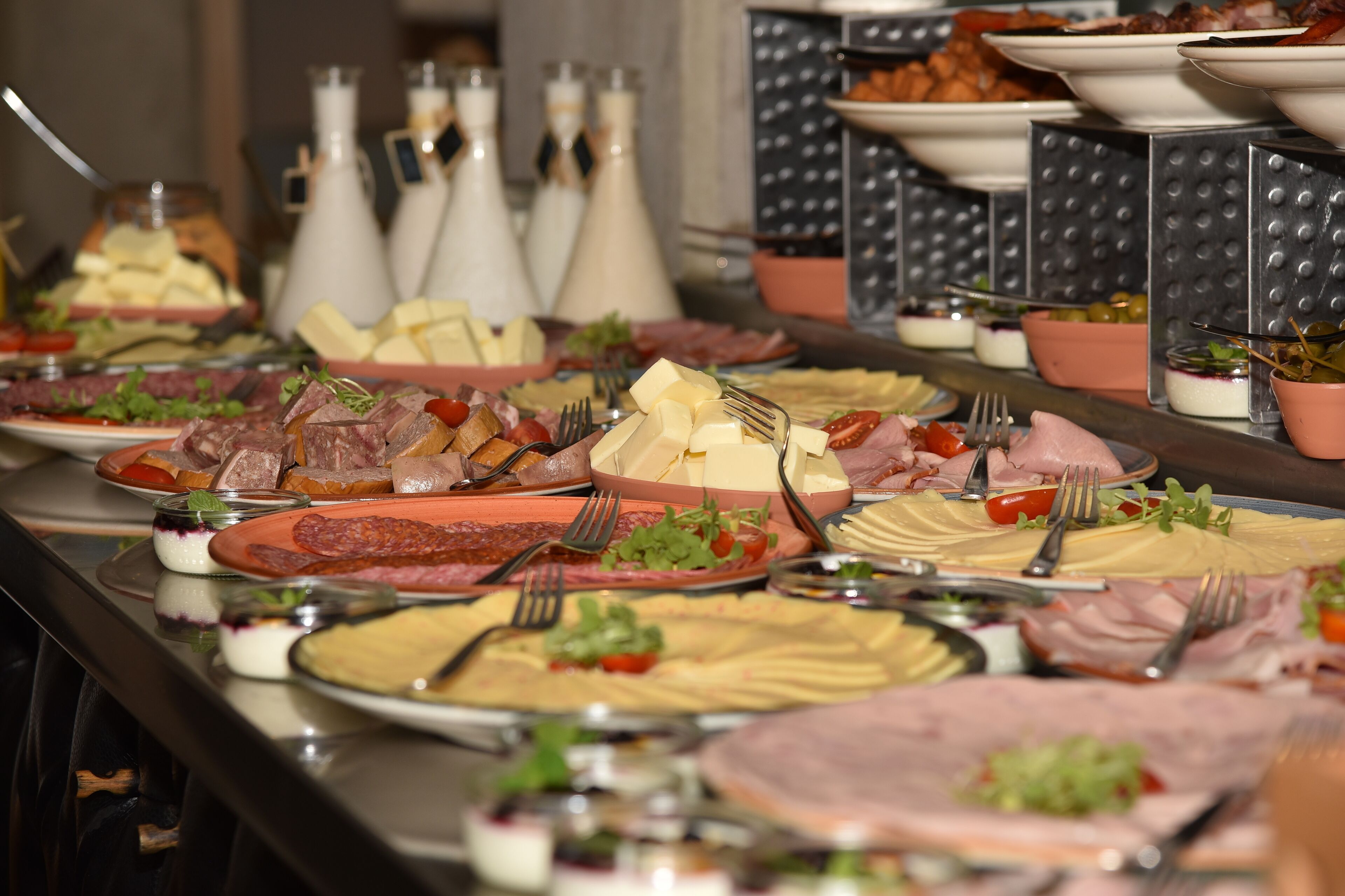 Ein Buffet mit verschiedenen Speisen, darunter Fleisch, Käse und Salate.