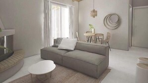 A modern living room with a grey sofa, a round coffee table, and a dining area with chairs and a table. - Avres Apartments (Skiathos)
