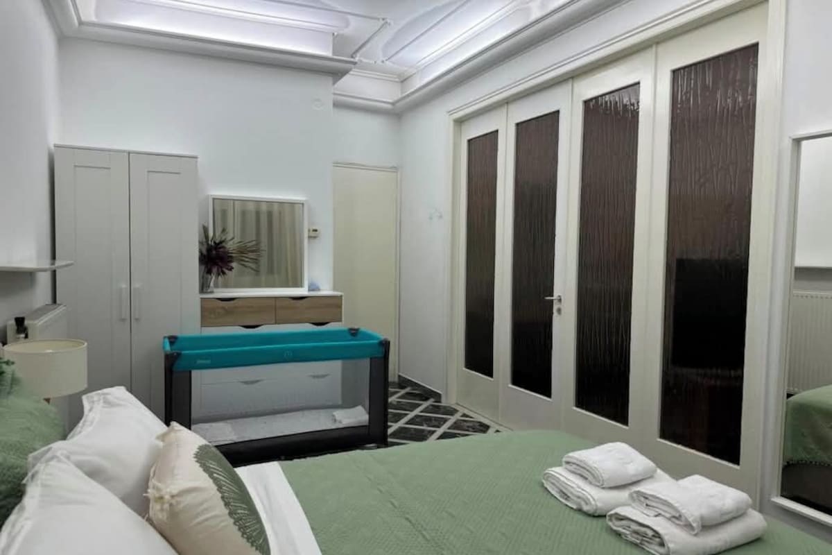 Habitació d'hotel amb llit, una panxa, mirall, armari i finestra.