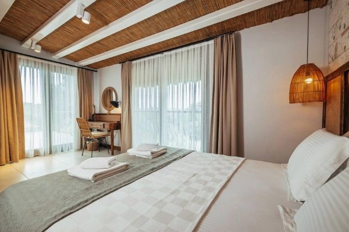 A hotel room with a bed, a desk, and a chair.