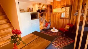 Un espacio habitable compacto con cocina, comedor y una hamaca.