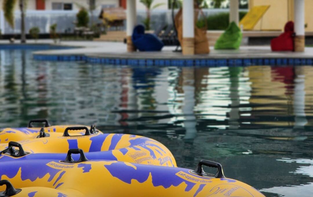 A pool area with inflatable rafts and lounge chairs.