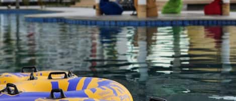 A pool area with inflatable rafts and lounge chairs.