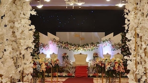 An indoor wedding venue with a red carpet, floral decorations, and a chandelier. - Aimas Hotel & Convention Centre (Sorong)