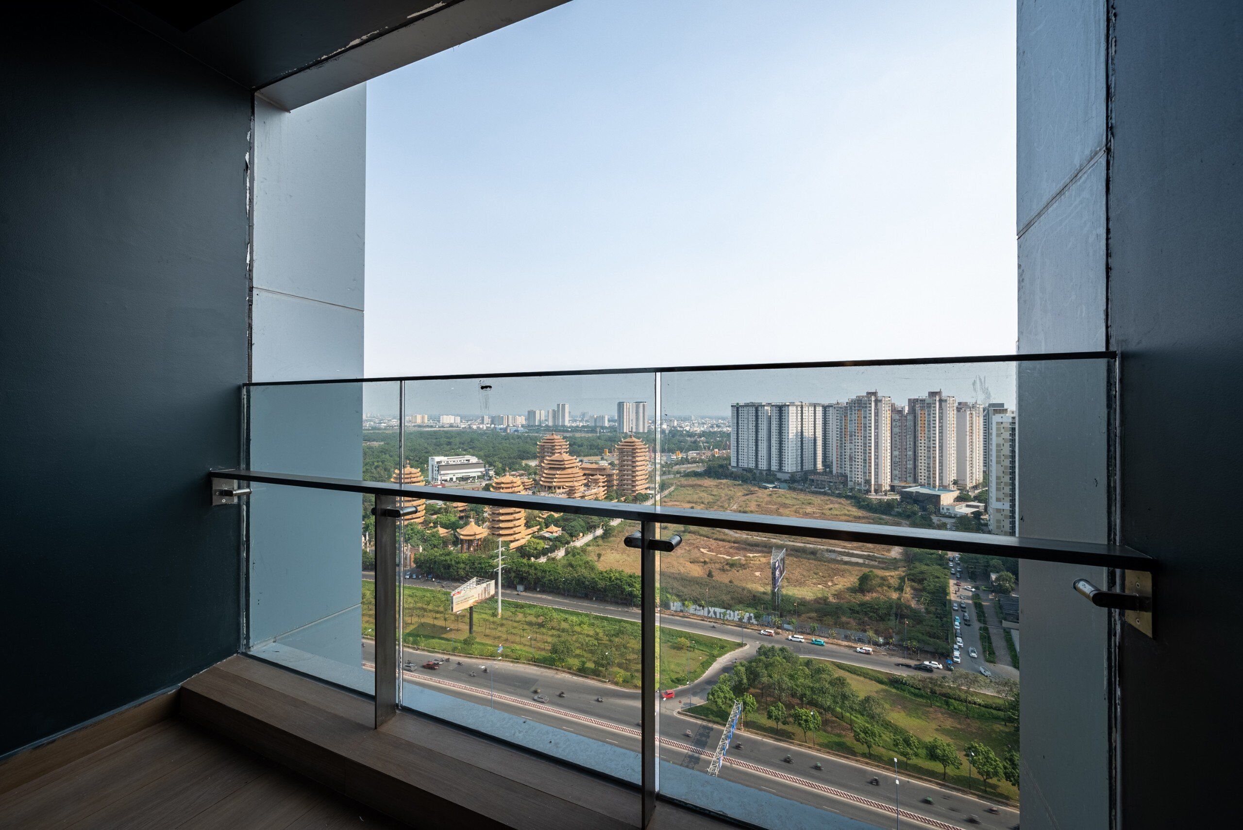 A high-rise building with a glass balcony overlooking a cityscape.