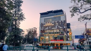 A multi-story building with signage for 'AURA' and '5 Star Premium Sweets'.
