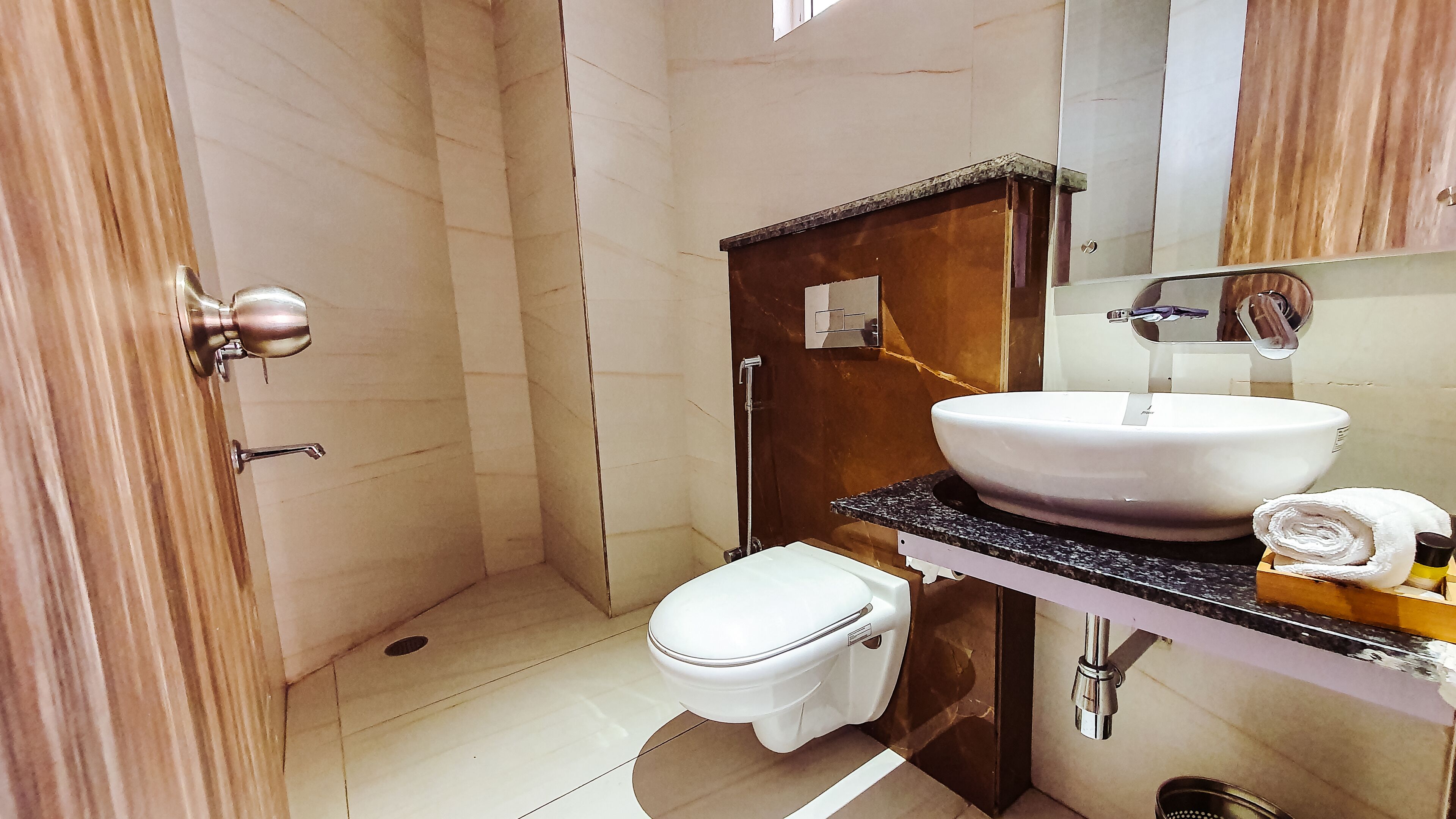 A bathroom with a shower, toilet, sink, and a mirror.