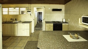 A compact kitchen with a granite countertop, a microwave, and a stove. There is a small sink and a refrigerator. - Oppi Stuppi Langebaan 4-Sleeper (Langebaan)