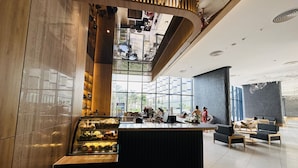 A modern lobby with a central counter, seating area, and large windows offering views. - Seaview Cam Ranh (Bac Cam Ranh)