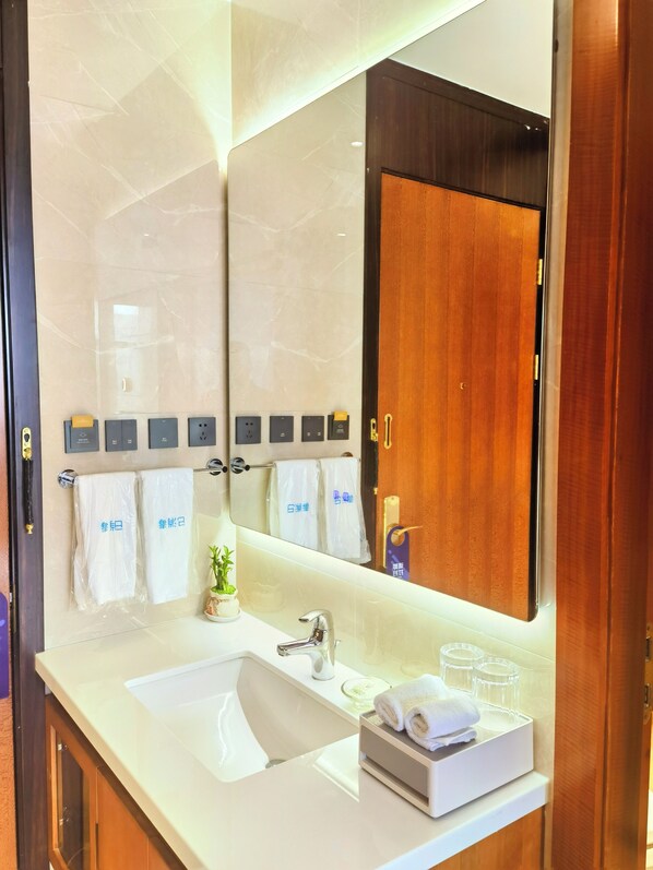 Un baño moderno con un espejo grande, dos lavamanos y un perchero para toallas.