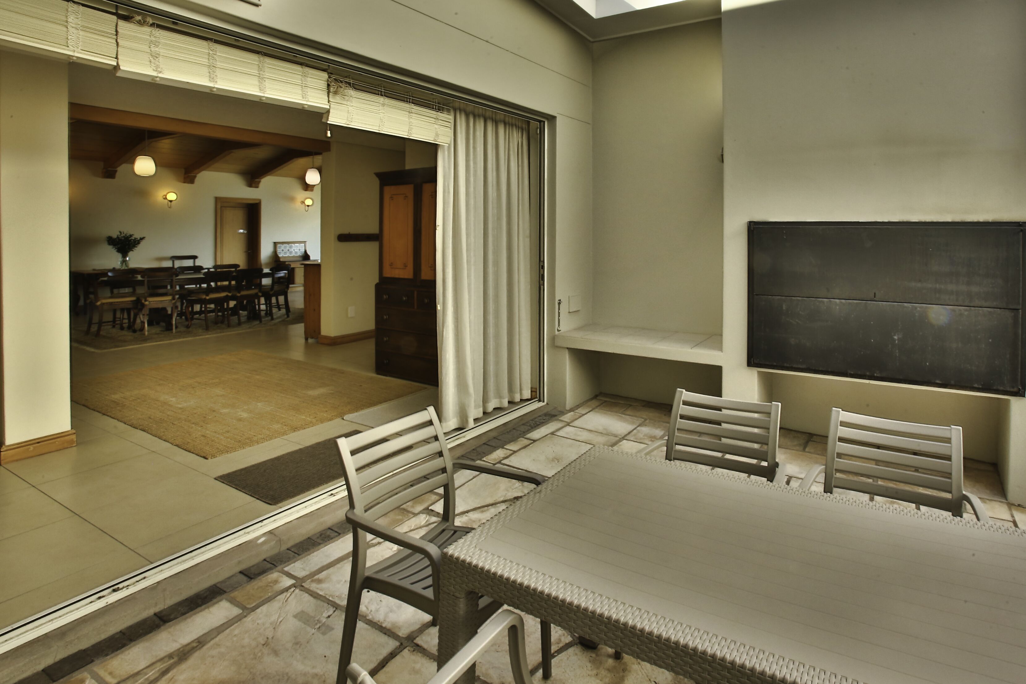 A spacious dining area with a large table and chairs, a view of the kitchen, and a sliding glass door leading to an outdoor patio.