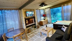 Uma sala de estar acolhedora com lareira, TV, mesa de bilhar e sofá.