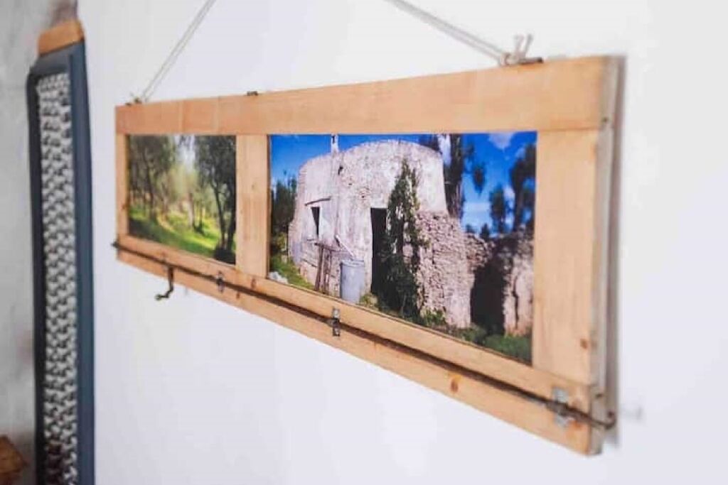 Ein gerahmtes Foto einer Steinstruktur mit Bäumen, möglicherweise eine historische Stätte, an einer Wand befestigt.