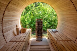 Una sauna con interni in legno, un sistema di riscaldamento centrale e vista su una vegetazione rigogliosa.