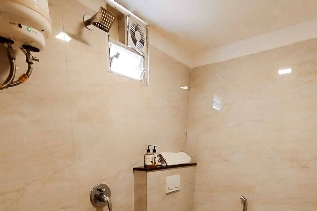 A compact bathroom with a sink, toilet, and shower.