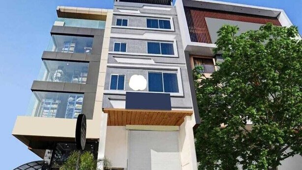 A modern multi-story building with a flat roof, large windows, and a visible entrance. - Hotel Silvotel Stays (Indore)