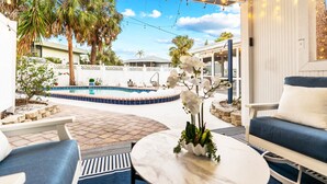 An outdoor patio with a pool, seating area, and string lights. - Exclusive complex - Private Heated Pool - 100 Steps to Beach - Village 5 minute walk (Siesta Key)