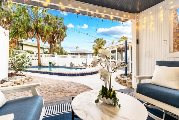 An outdoor patio with a pool, seating area, and string lights. - Exclusive complex - Private Heated Pool - 100 Steps to Beach - Village 5 minute walk (Siesta Key)
