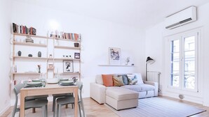 Una sala moderna con una mesa de comedor, sofá y estantería.