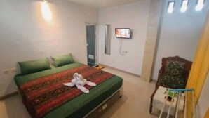 A hotel room with a bed, a television, a chair, and a small table. - Hotel O Balekui Homestay (Pujut)