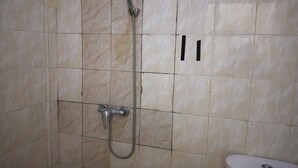 A bathroom with a shower, a toilet, and a wall-mounted towel rack. - Hotel O Balekui Homestay (Pujut)