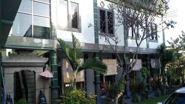 A two-story building with a symmetrical facade, large windows, and a central entrance. - Hotel O Balekui Homestay (Pujut)