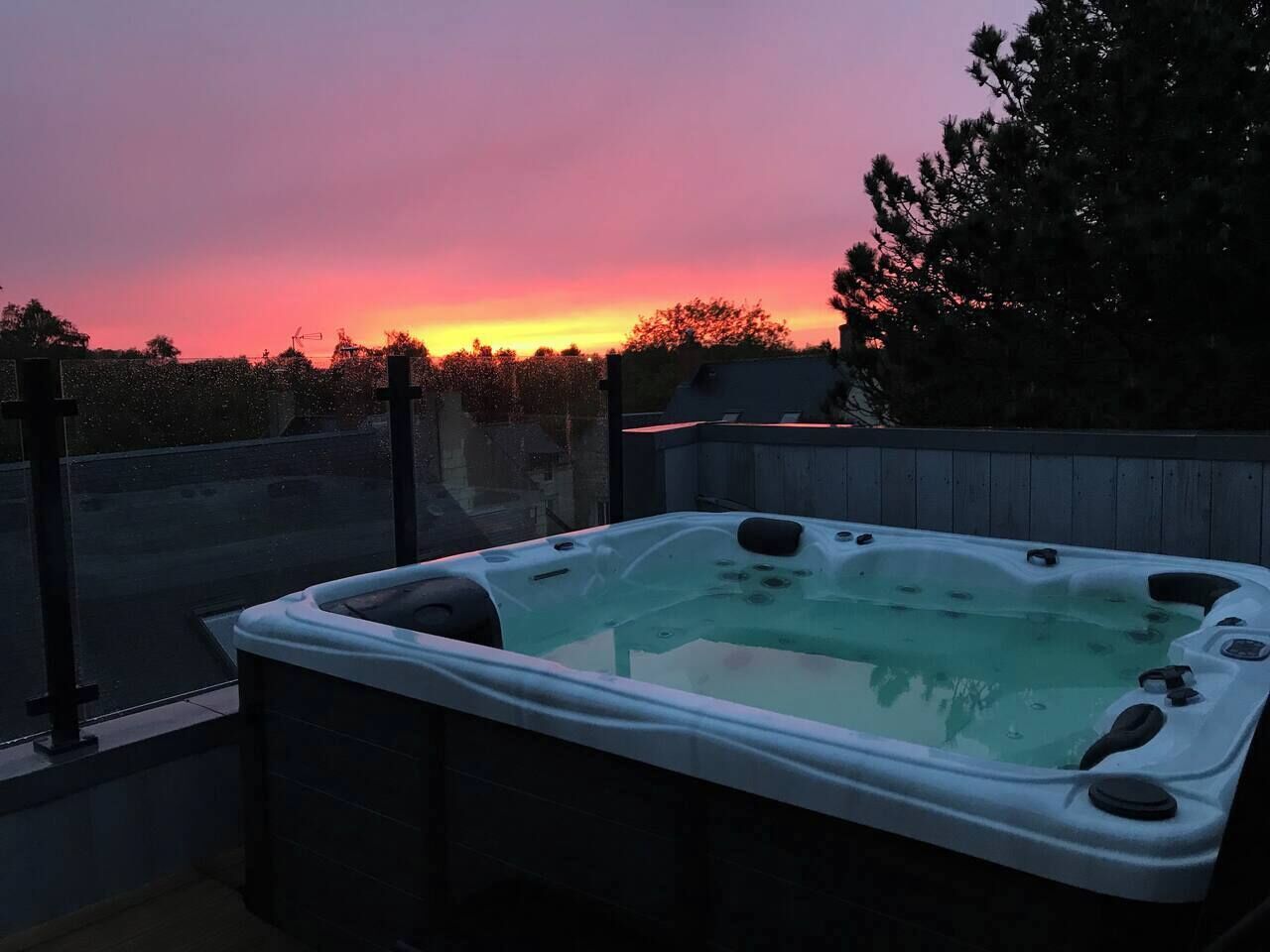 Ein Whirlpool auf einem Balkon mit Sonnenuntergangblick.