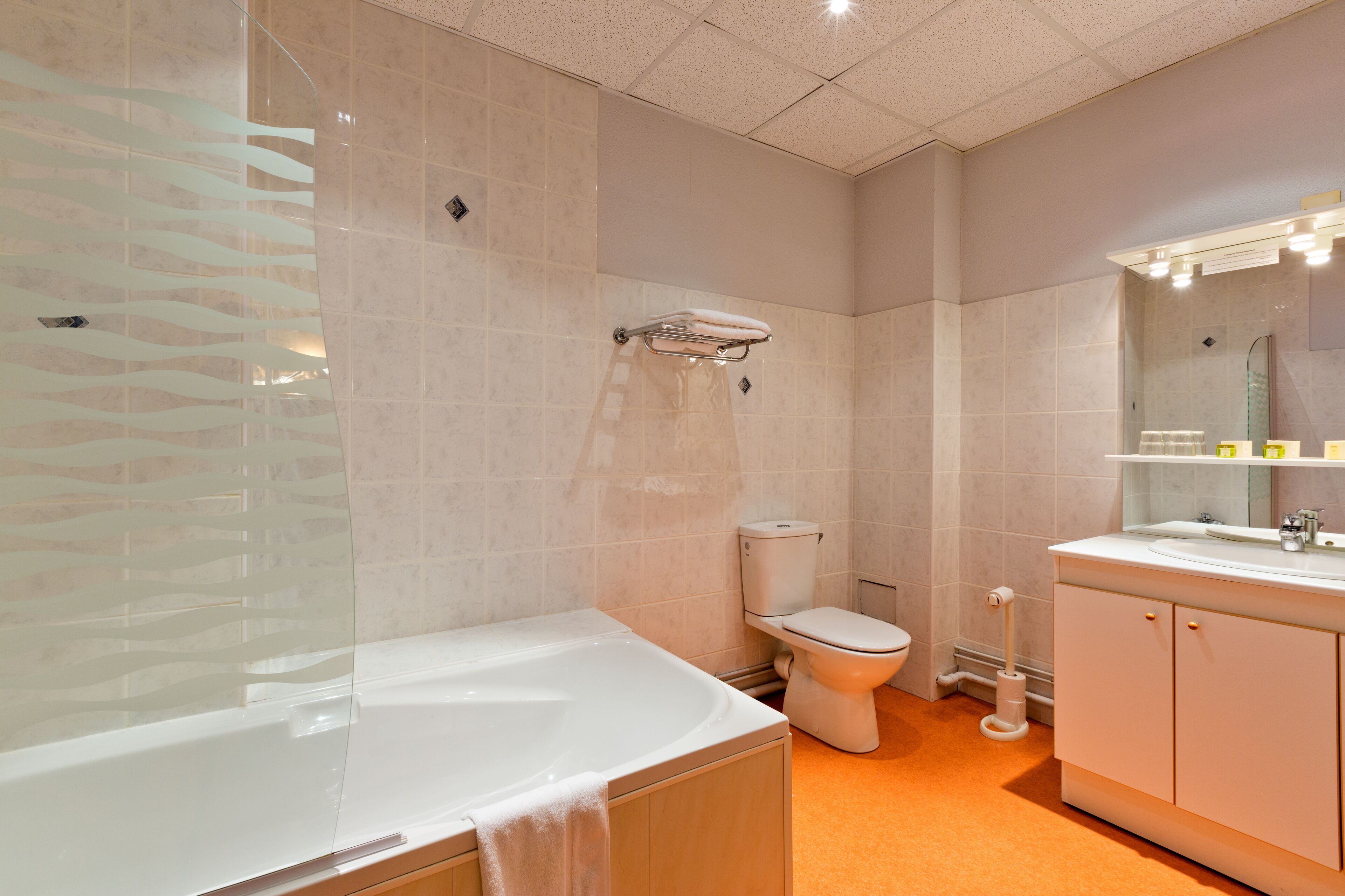 Een moderne badkamer met bad, toilet en wastafel.