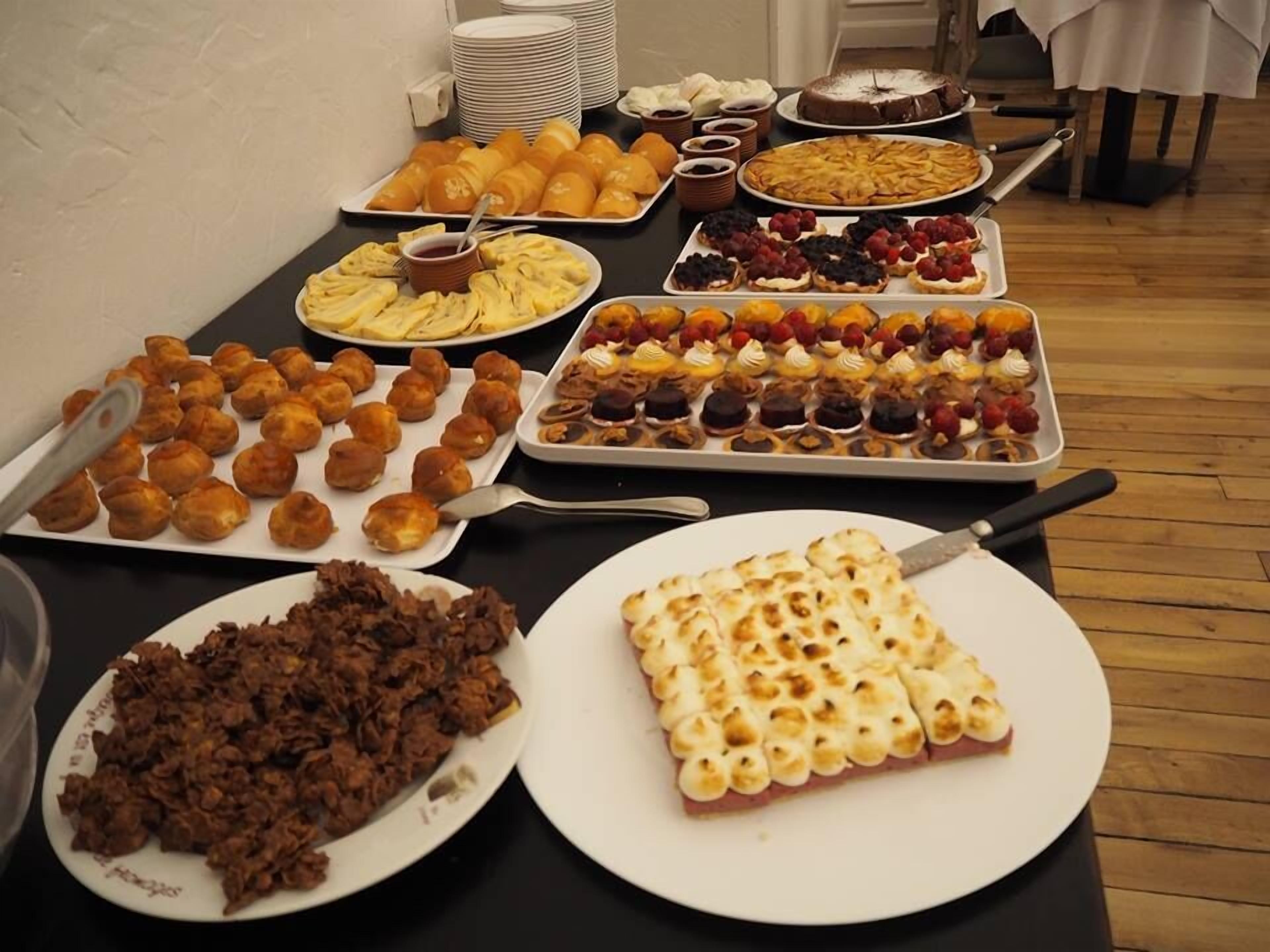 A buffet table with various desserts and pastries.