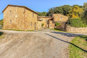 A stone building with a gravel driveway leading to a paved road. - Apartment for family (colle di val d'elsa)