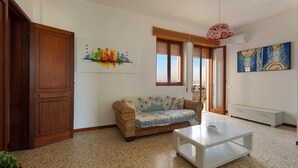 A living room with a sofa, a coffee table, and artwork on the walls. - 3730 Appartamento Valencia by Barbarhouse (Porto Cesareo)